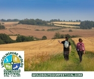 People walking through a field pointing at something